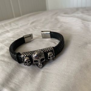 Black leather bracelet with steel skulls. Black gemstones in eyes.